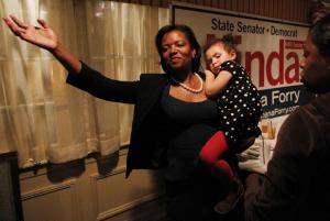 Linda Dorcena Forry held her daughter Madeline Forry, 2, as she celebrated a possible close victory at Phillips Freeport Tavern in Dorchester. (taken before Nick Collins conceded.)